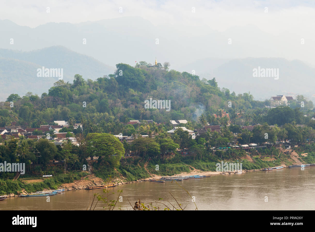 Bateaux amarrés sur le fleuve Mékong, ville de Luang Prabang, le Mont Phousi (Phou Si, Phusi, Phu Si) et les montagnes en arrière-plan à Luang Prabang, Laos. Banque D'Images