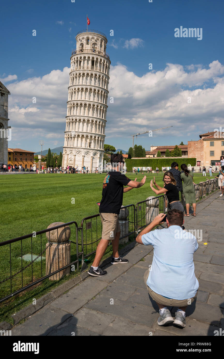 Tourist qui pose pour photo contre la tour penchée de Pise, Toscane, Italie Banque D'Images