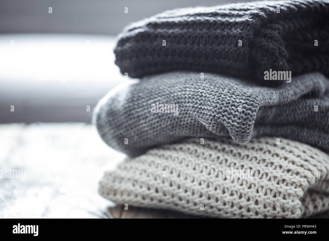 Pile de pulls confortables sur fond de bois. Concept L'automne-hiver Banque D'Images