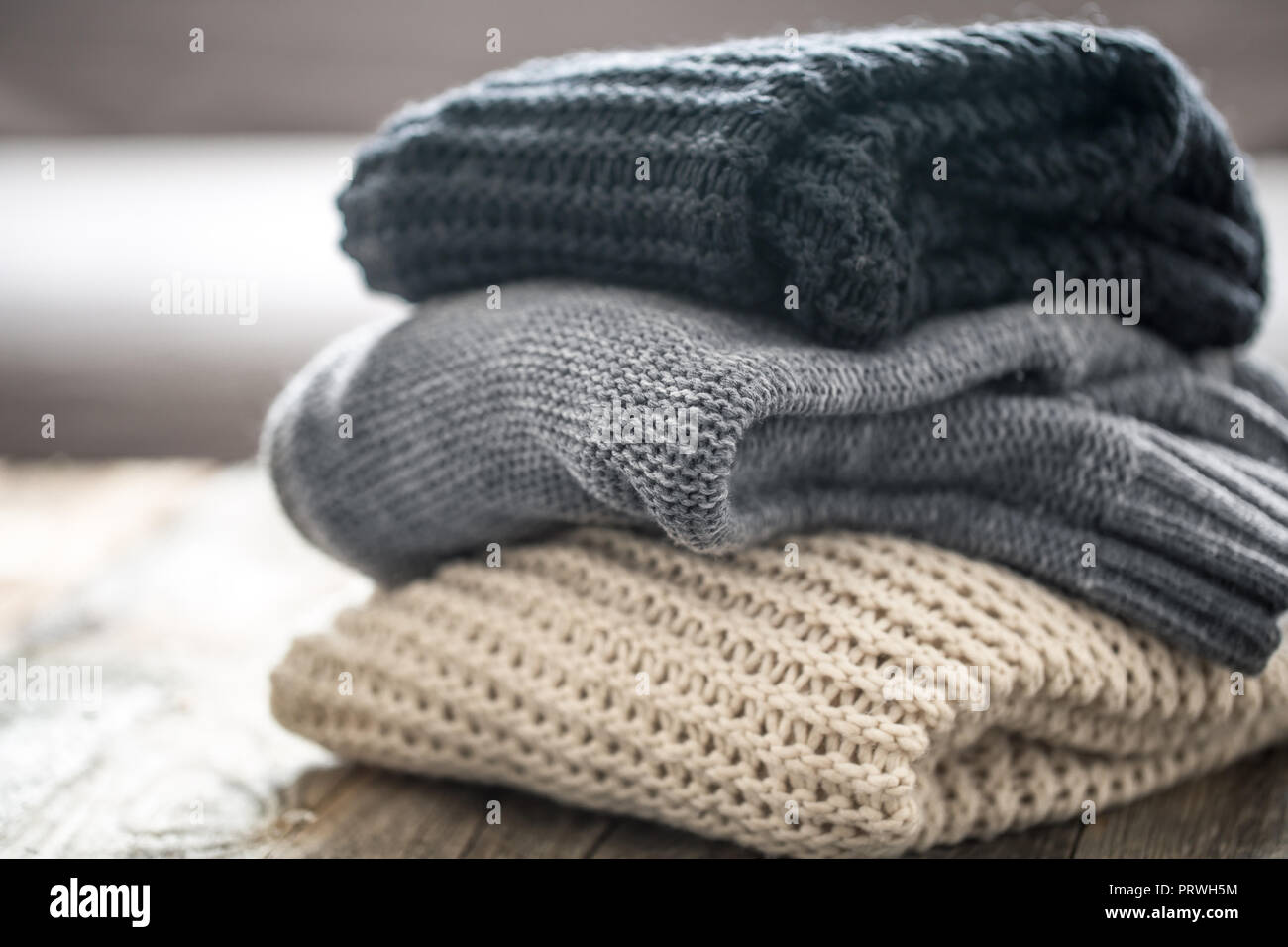 Pile de pulls confortables sur fond de bois. Concept L'automne-hiver Banque D'Images