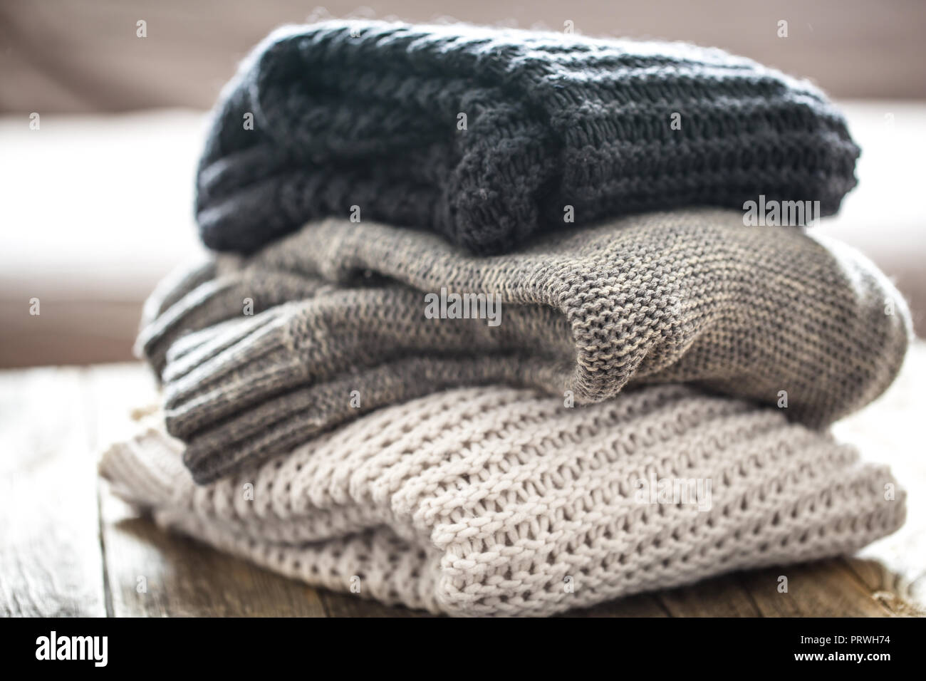 Pile de pulls confortables sur fond de bois. Concept L'automne-hiver Banque D'Images