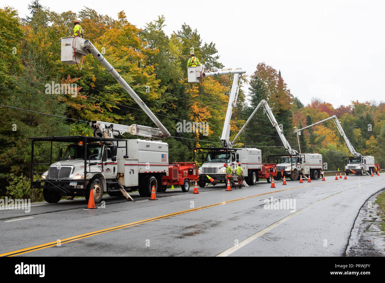 Une flotte de véhicules de service se sont réunis dans la montagnes Adirondacks, NY USA arbres et branches de fraisage à l'écart des lignes électriques. Banque D'Images