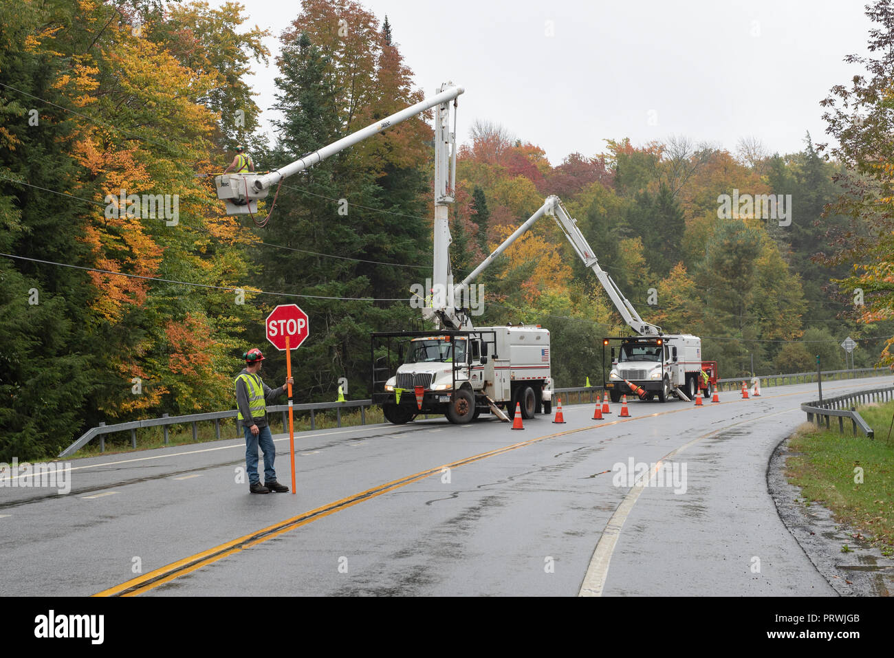 Une flotte de véhicules de service se sont réunis dans la montagnes Adirondacks, NY USA arbres et branches de fraisage à l'écart des lignes électriques. Banque D'Images
