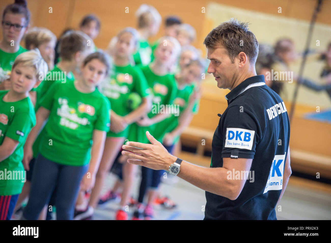 05 octobre 2018, Berlin : Christian Prokop (r), entraîneur de handball nationale, mène un programme de formation avec des élèves de l'école primaire Am Faulen Voir. L'école primaire de Berlin avait gagné un cours de formation de handball avec l'entraîneur national Prokop dans un projet d'école nationale de la Fédération allemande de Handball (DHB) et l'AOK. Avec ce projet, les deux partenaires veulent motiver les enfants pour plus d'exercice et de handball. Photo : Arne Immanuel Bänsch/dpa Banque D'Images