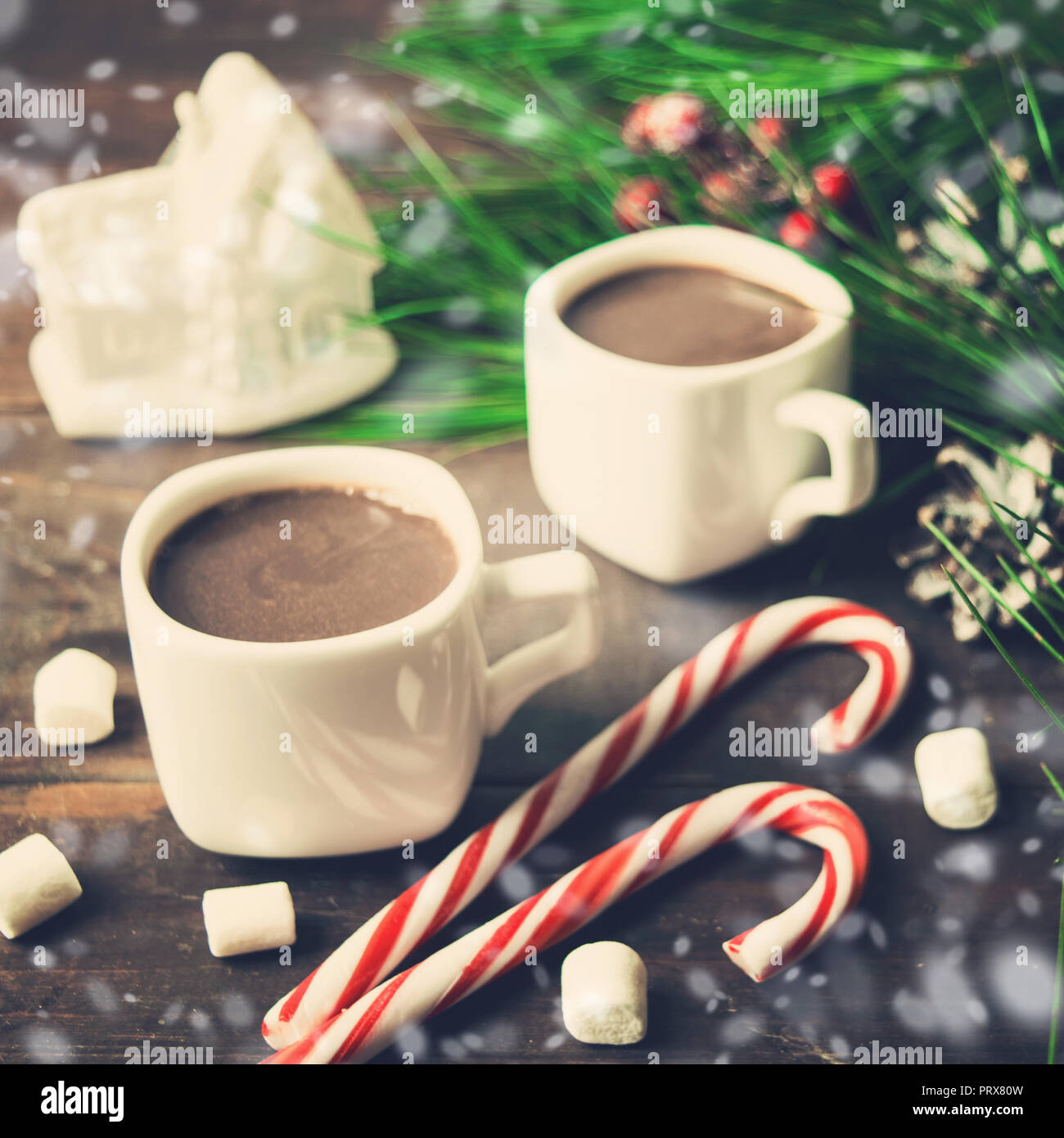 Chocolat chaud avec guimauves et sucettes avec des décorations de Noël sur fond de bois, photo aux tons Banque D'Images