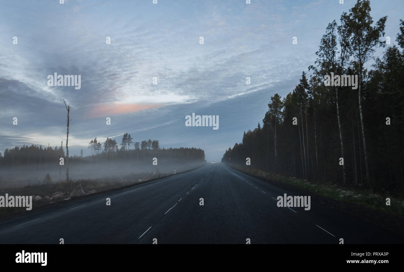 Un matin d'automne brumeux sur la route en Finlande avec les champs sur le côté Banque D'Images