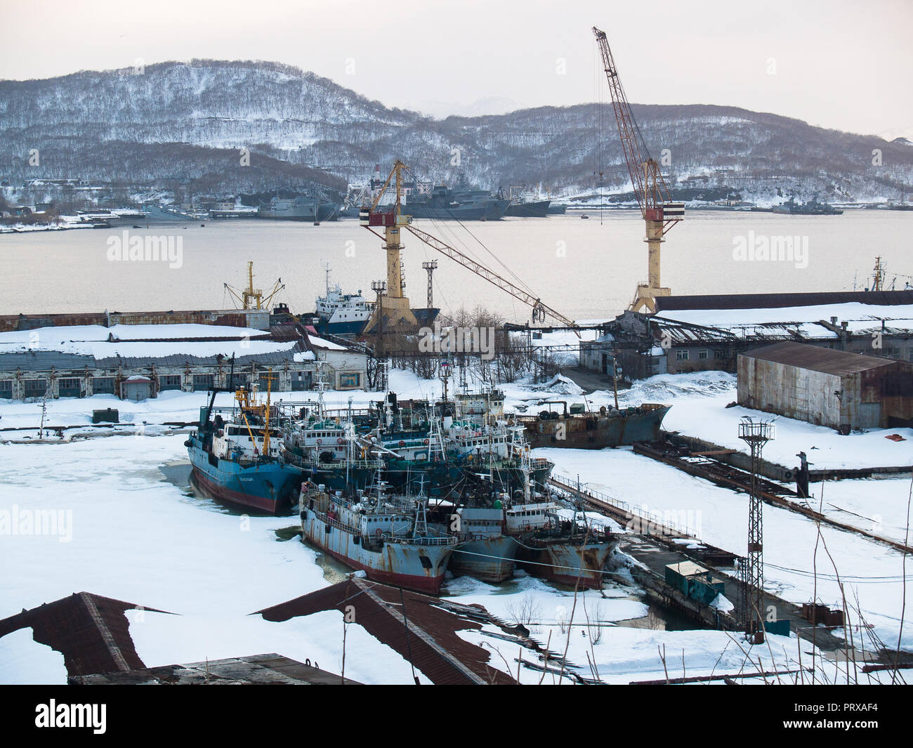 Dans le chantier naval docks il y a des bateaux de pêche pour les réparations près de la baie avec vue sur les collines en hiver à Yichun dans la soirée à Banque D'Images