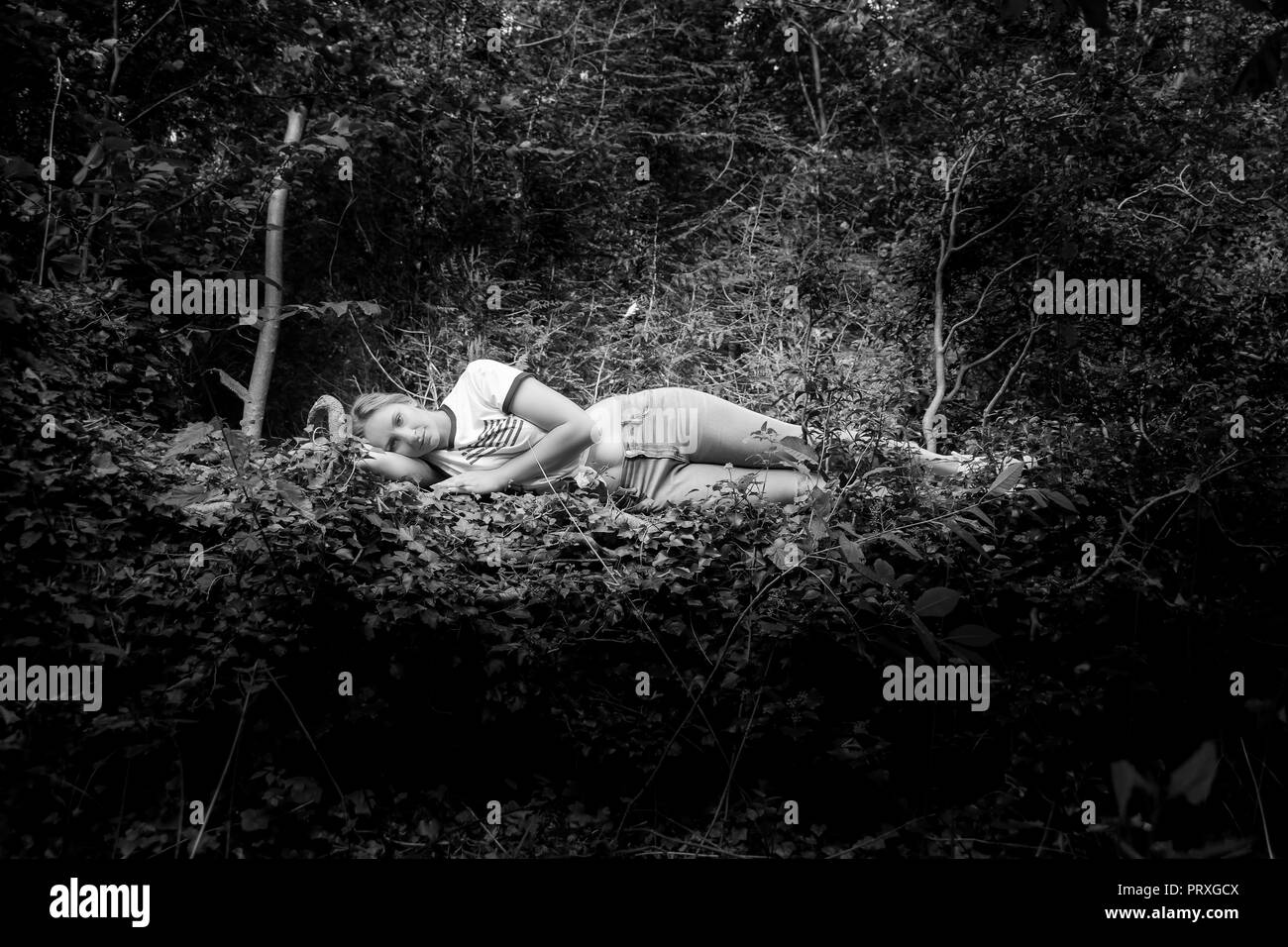 En communion avec la nature. Une femme blonde se trouve dans une forêt Banque D'Images