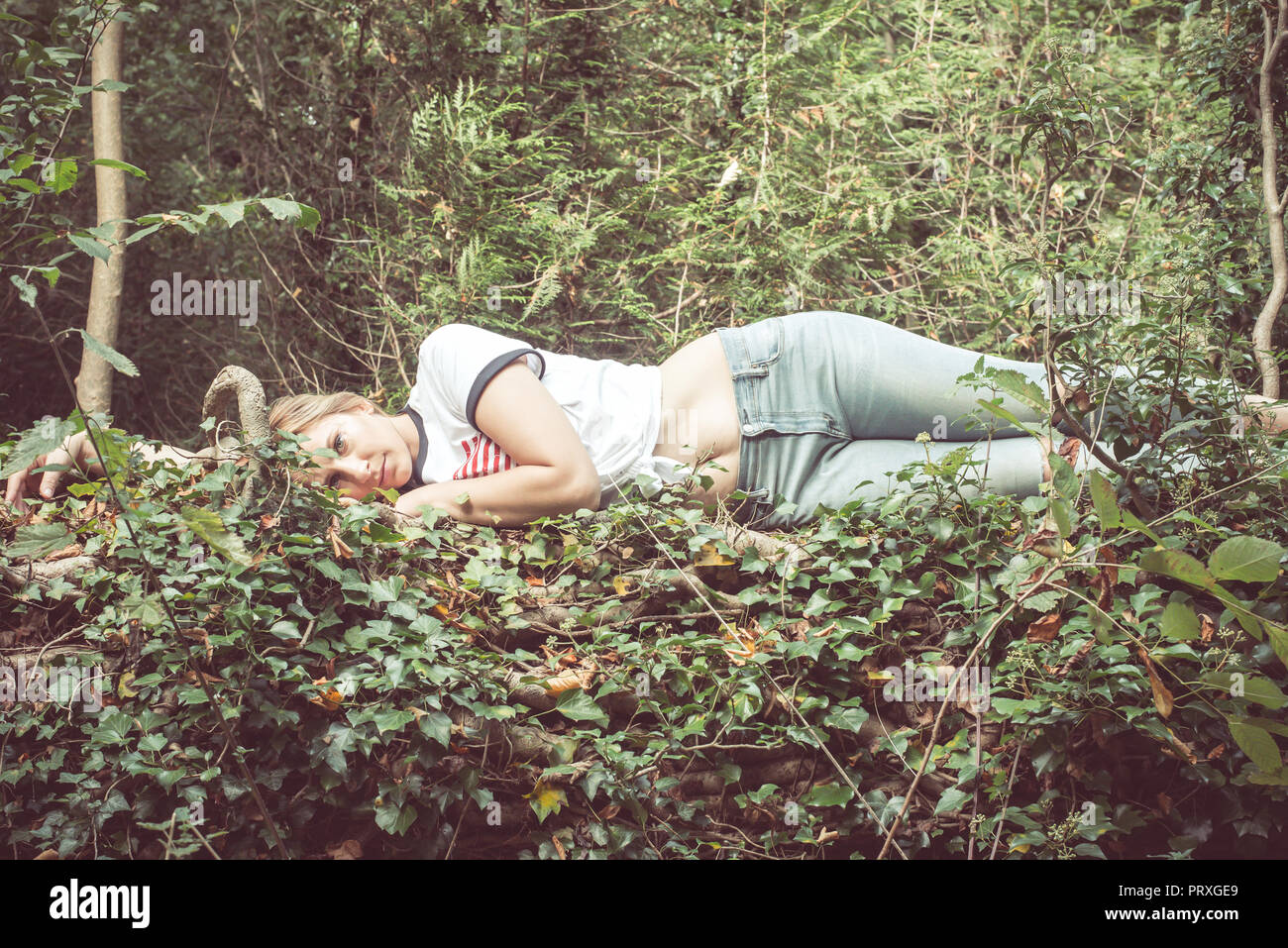 En communion avec la nature. Une femme blonde se trouve dans une forêt Banque D'Images