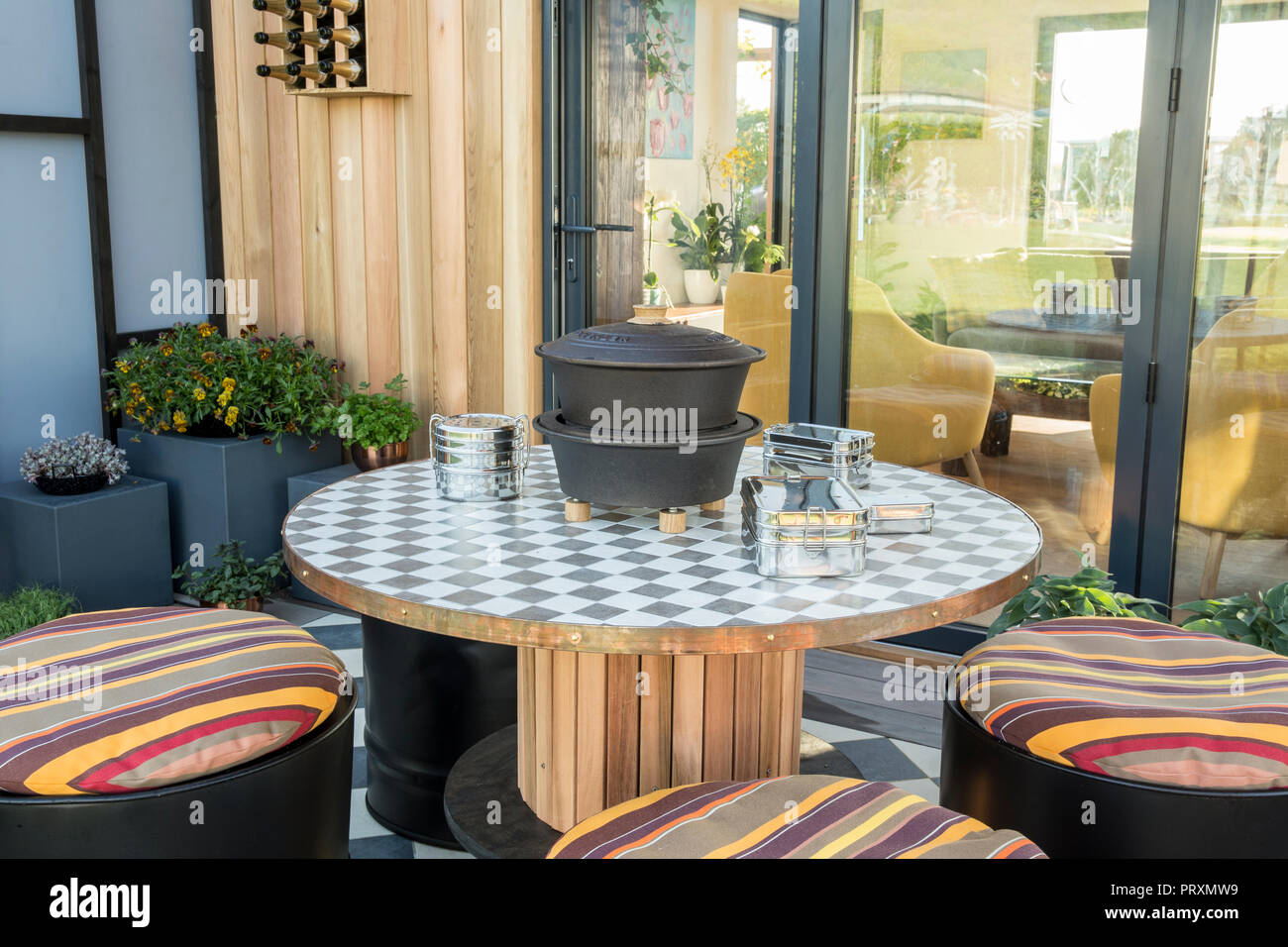 Balcon jardin avec table et sièges en bois recyclé réaffectés, coussins, coin salon extérieur patio, violas, succulentes et micro greens UK Banque D'Images