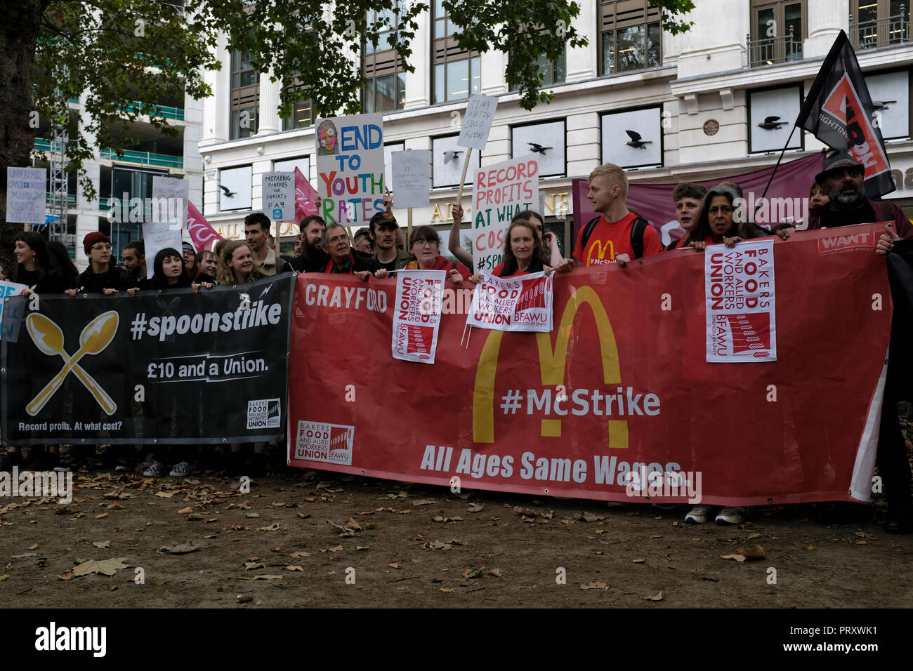 Les travailleurs de l'industrie alimentaire rapide vu debout derrière d'immenses bannières à l'extérieur de Mc Donalds pendant la manifestation. TGI Fridays, Wetherspoons, et McDonald's ensemble rassemblement de travailleurs à Londres pour réclamer de meilleures conditions de travail et une rémunération équitable dans l'industrie de l'accueil. Banque D'Images