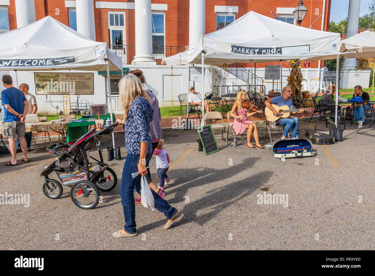 Nashville, TN, USA-9/29/18 : deux musiciens, jouer de la musique au marché des agriculteurs, tandis que deux femmes avec un petit enfant et un bébé poussette de marche par. Banque D'Images