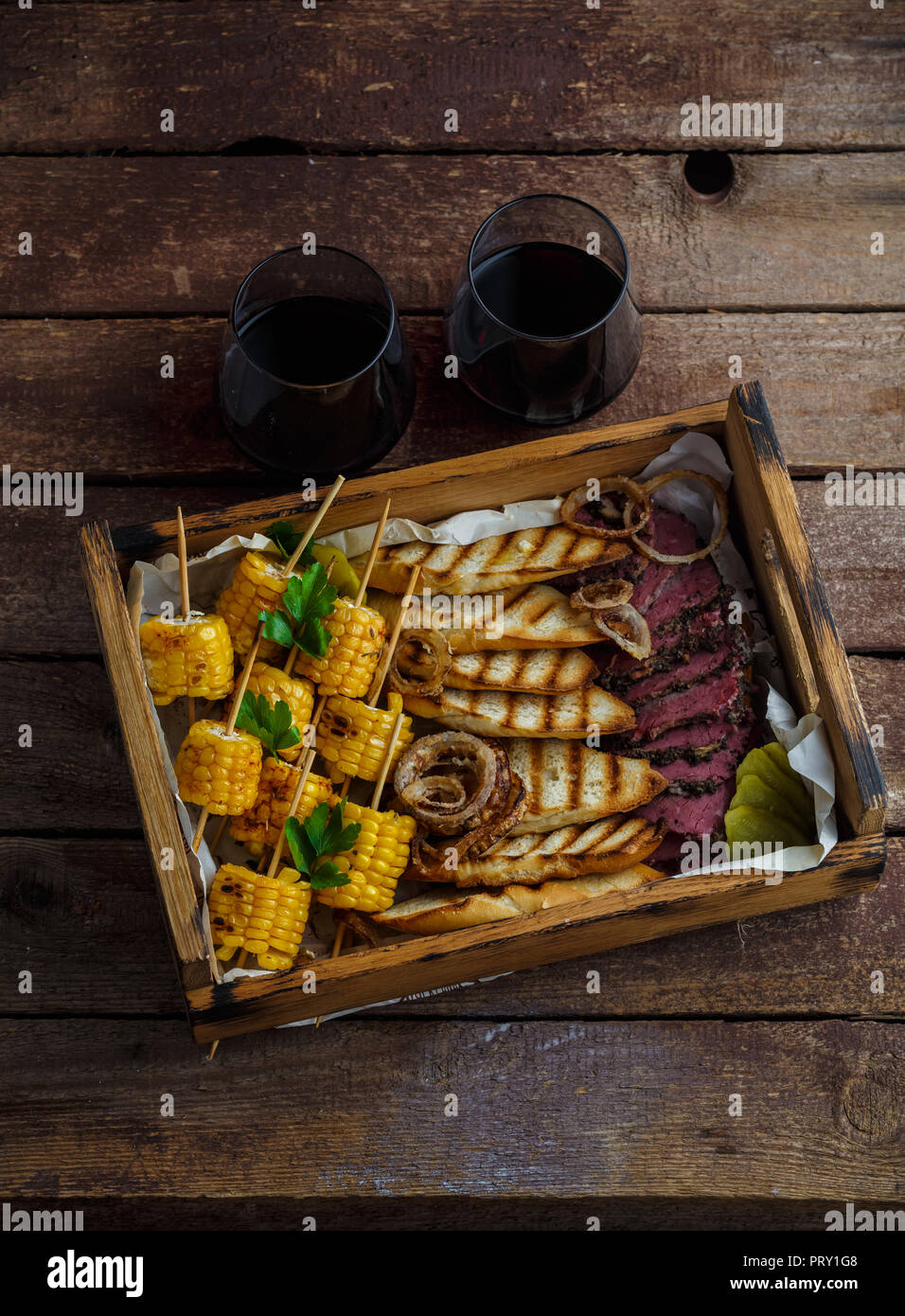 Maïs grillé, tranches de pastrami et pain grillé avec du vin, vue de dessus de l'espace de copie. Banque D'Images