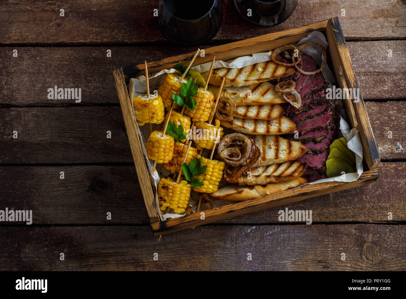 Maïs grillé, tranches de pastrami et pain grillé avec du vin, vue de dessus de l'espace de copie. Banque D'Images
