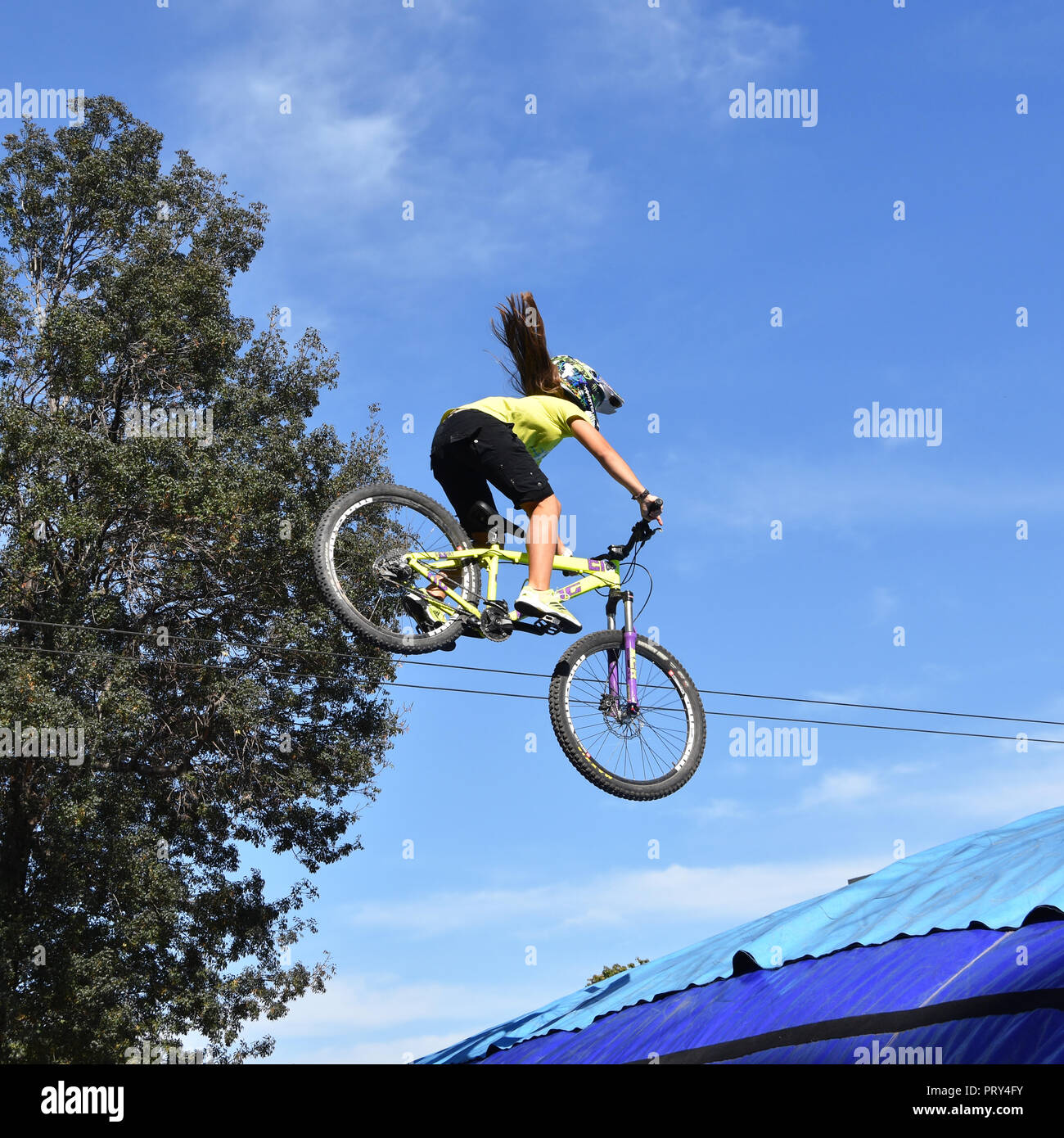 Jeune femme freestyle stunt cyclist volant dans le ciel avec son vélo effectuant un saut de skate-park Sofia rampe durant le Festival des sports extrêmes Banque D'Images