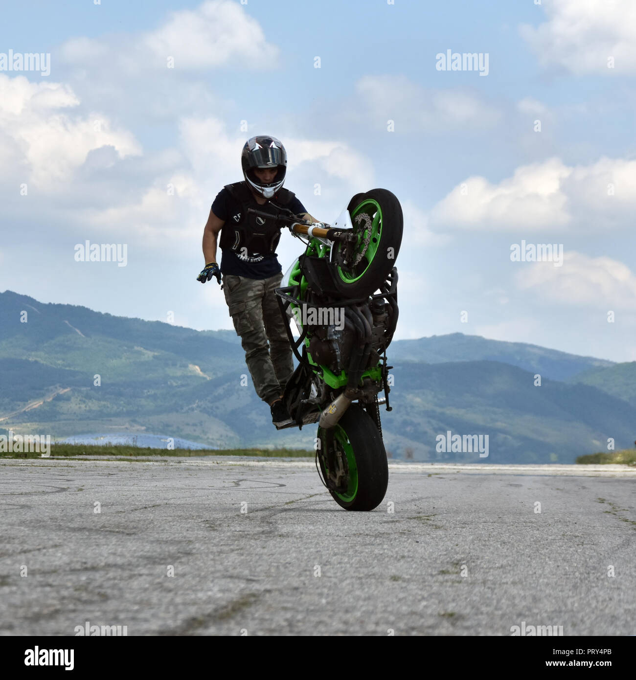 Stunt moto en action. Jeune homme biker freestyle extrême sur l'échelle de formation abandonnés vides airplane Banque D'Images