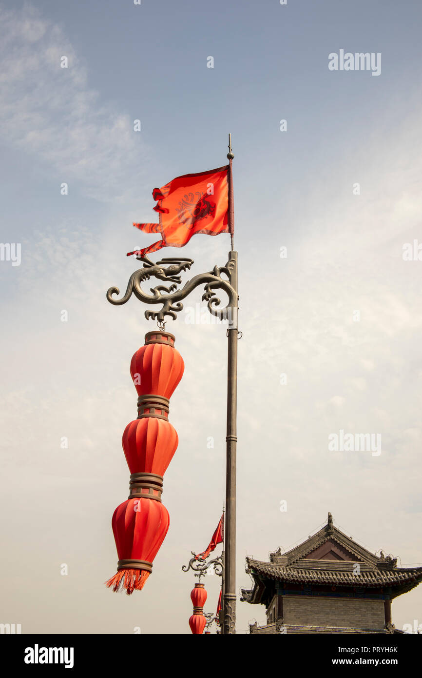 Mât dragon orné avec un drapeau et des lampions rouges contre un ciel bleu avec le vieux mur sud pagode à Xi'an, Shaanxi Providence, en Chine. Banque D'Images