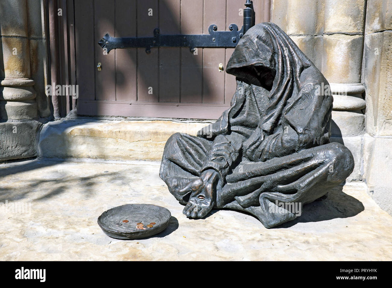 Jésus le mendiant sculpture basé sur Matthieu 25:40, créé par Timothy Schmalz, est assis à l'extérieur de la vieille église en pierre à Cleveland, Ohio, USA. Banque D'Images
