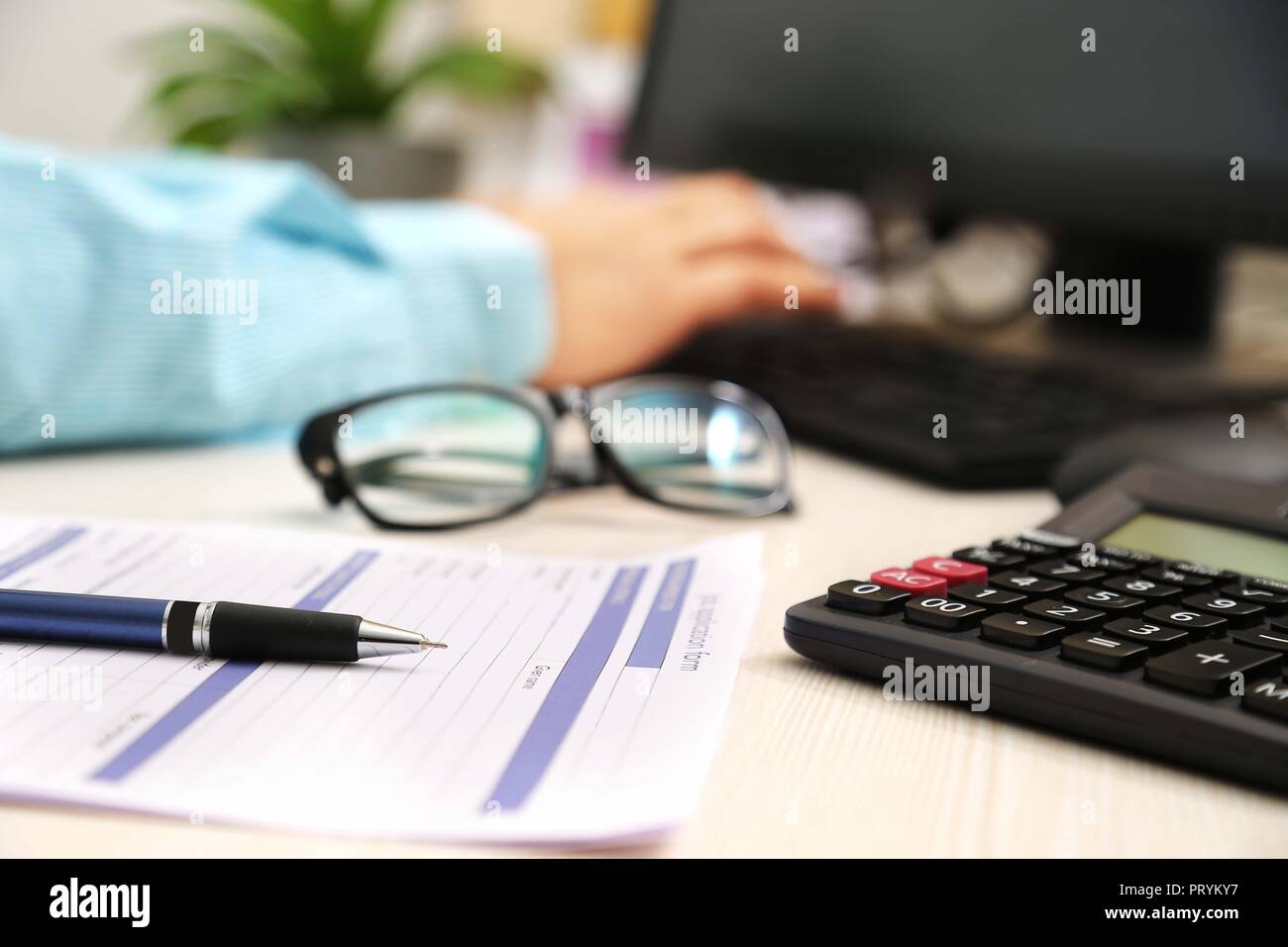 Photo de l'homme est de taper au clavier. Photo du formulaire de demande, un stylo, calculatrice et lunettes. Banque D'Images