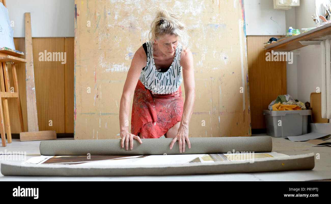 Femme peintre dans son atelier, enrouler la peinture Banque D'Images