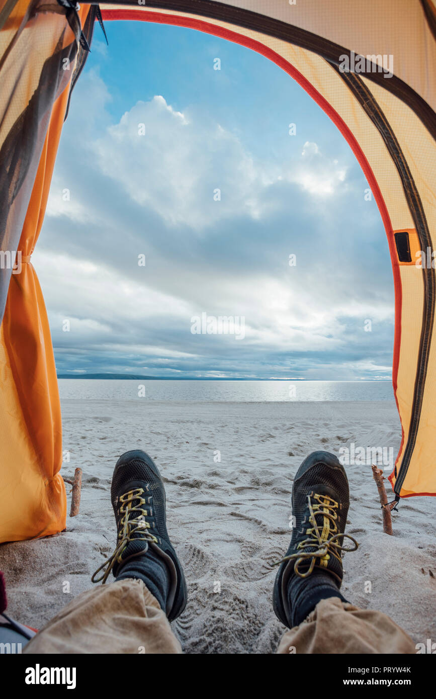 Pieds de l'homme, couché dans la tente sur la plage Banque D'Images