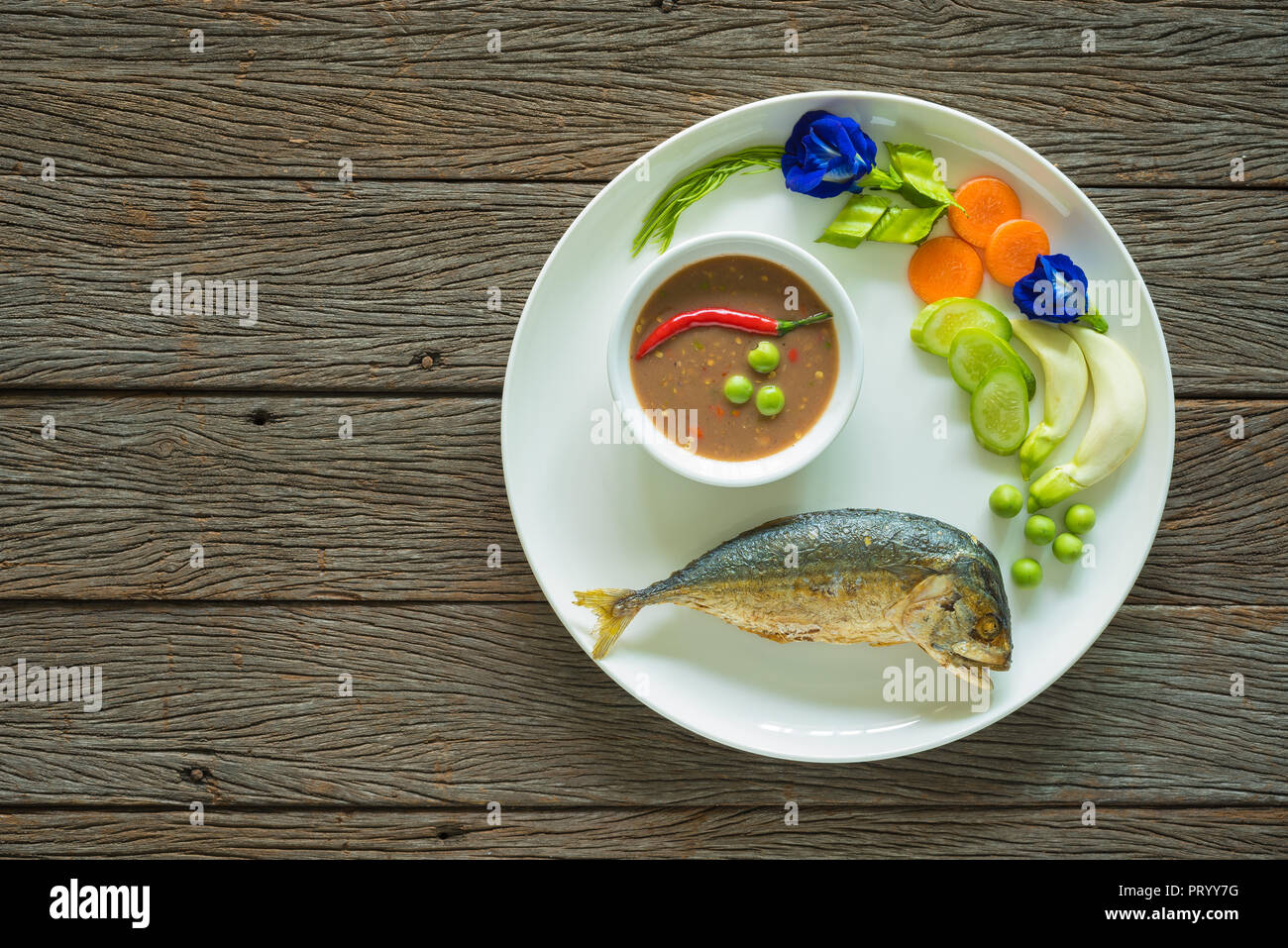 Le Maquereau frit avec sauce chili pâte de crevettes et de légumes frais sur la table en bois Banque D'Images