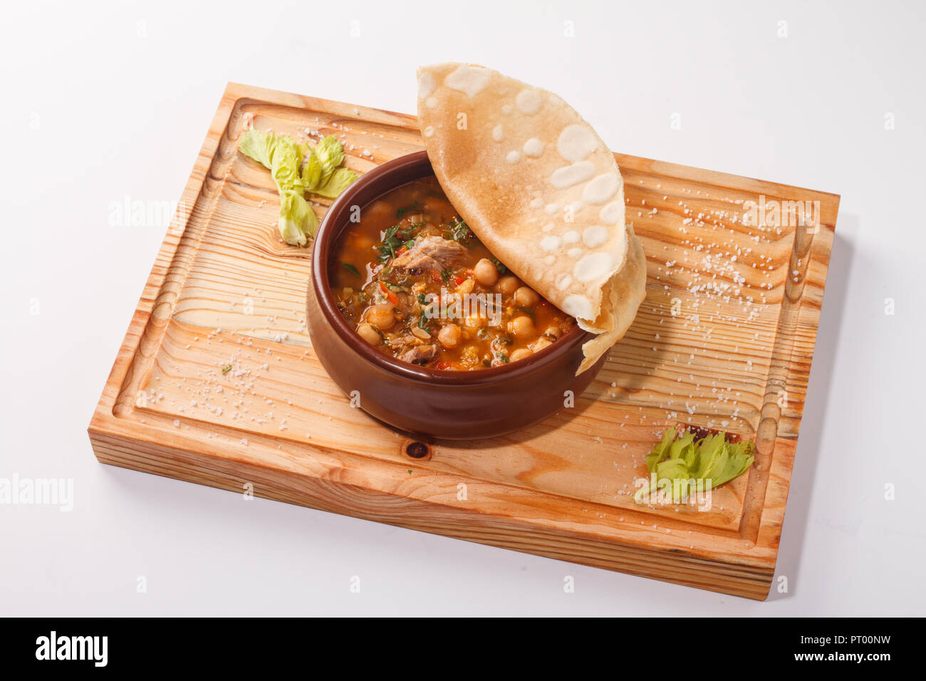 Putuk / Piti - ragoût arménien traditionnel de pois chiches et d'agneau servi dans un pot en argile recouvert d'un pain plat. Banque D'Images