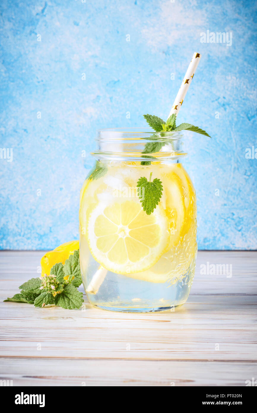 Cocktail pot de limonade et de feuilles de menthe sur fond bleu table en bois de l'eau naturelle de citron sont populaires en verre de boissons detox infusion d'antioxydants. Banque D'Images