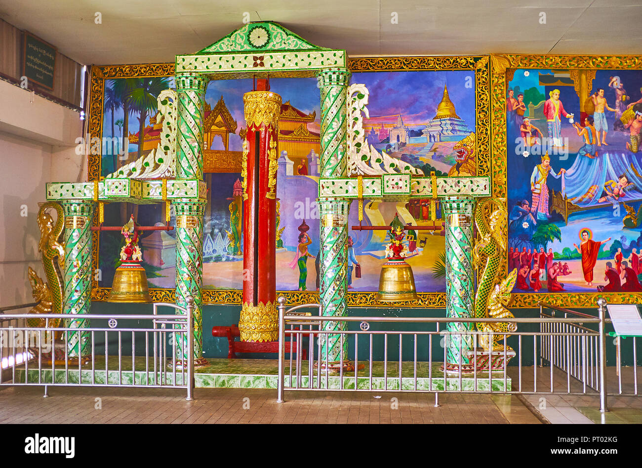 YANGON, MYANMAR - février 27, 2018 : les cloches, décorées avec miroir panoramique au mur coloré avec des peintures murales à Chaukhtatgyi, Temple du Bouddha d'o Banque D'Images