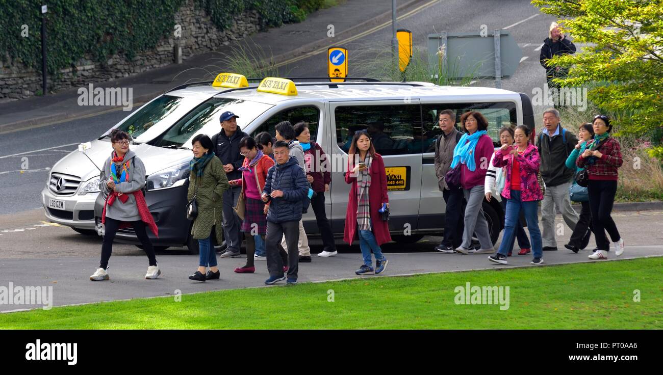 Un groupe de touristes chinois marche autour de Bowness on Windermere Lake District,,Cumbria, Angleterre, Royaume-Uni Banque D'Images