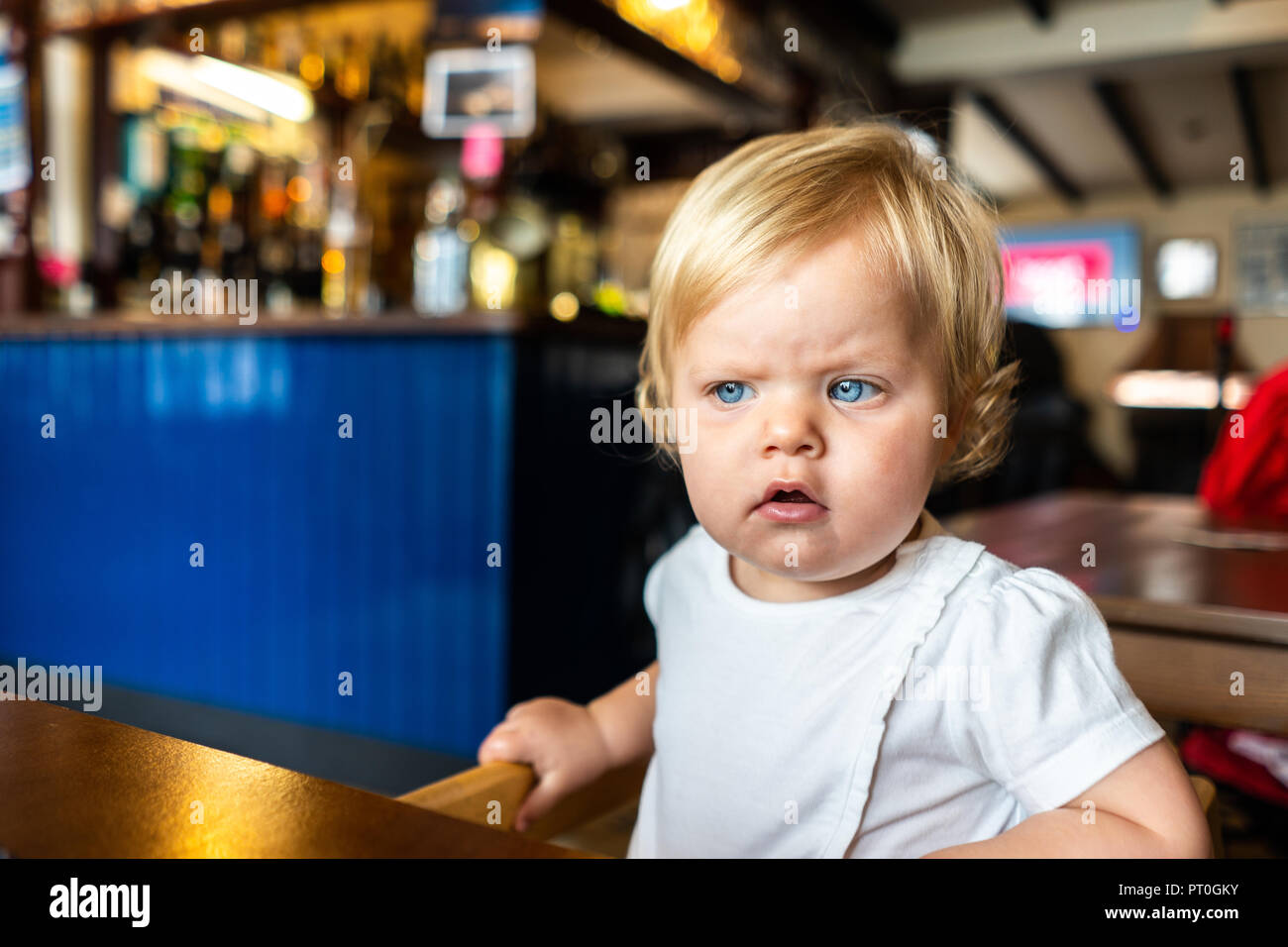 Une Magnifique Petite Fille Aux Yeux Bleus Lumineux S Asseoir Dans Sa Chaise Haute En Attente Pour L Alimentation Et De Prendre Un Verre Dans Une Maison Publique De Cornwall Photo Stock Alamy