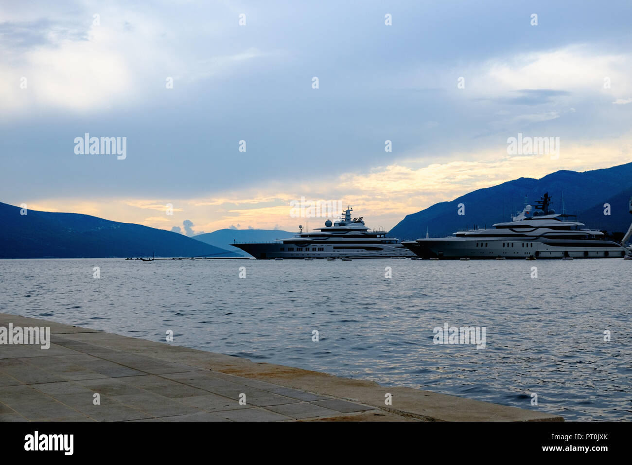 Bateau de tourisme dans la mer dans la soirée du soleil sur de belles grandes montagnes, l'arrière-plan d'aventure estivale de luxe, vacances actives à Tivat, Monténégro Banque D'Images