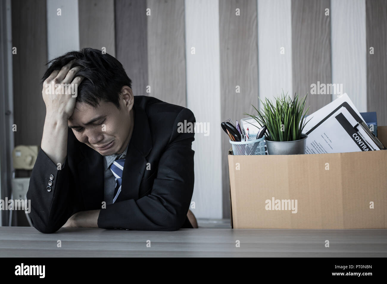 Triste homme au chômage assis et qui crie dans office, personne d'affaires préparer et nettoyer la table de travail après avoir relâché ou annuler pour faire un travail Banque D'Images