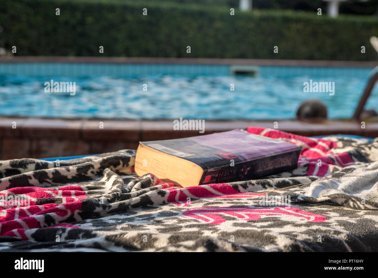 Livre sur une serviette, transats au bord de la piscine, le meilleur concept de vie, de détente, de relaxation, de refroidissement, de l'été, temps de détente extérieure livre, unplugged Banque D'Images