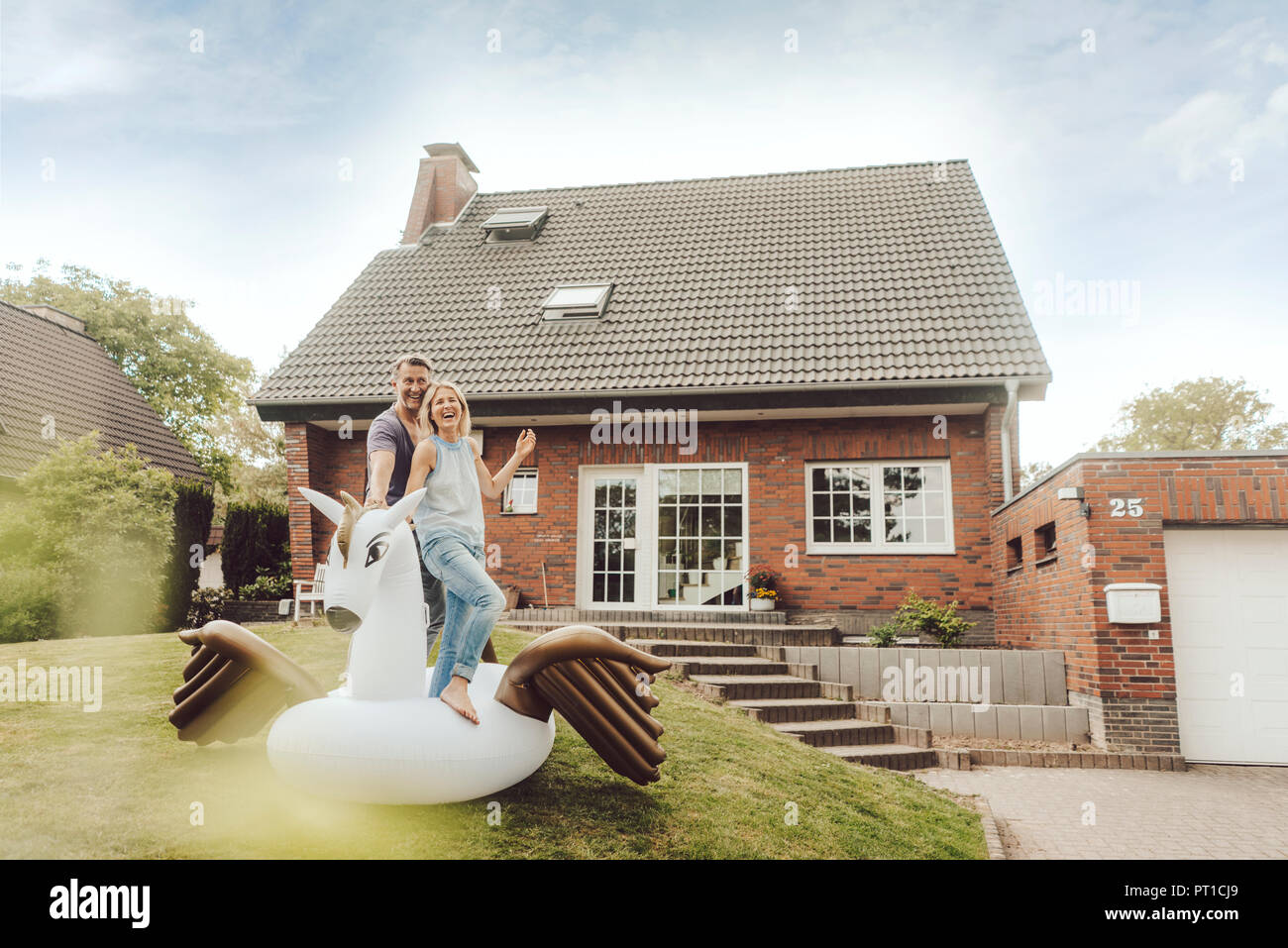 Couple avec piscine gonflable jouet dans jardin de leur maison Banque D'Images