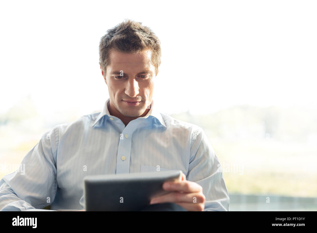 Poland, Warzawa, businessman using tablet computer au salon de l'hôtel Banque D'Images