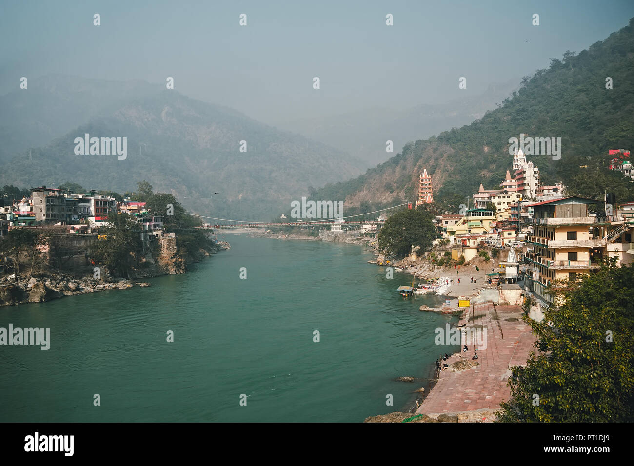 Vue de la rivière Ganga et Lakshman Jhula bridge dans Rishikesh. montagnes dans la brume. smog sur la ville. Banque D'Images