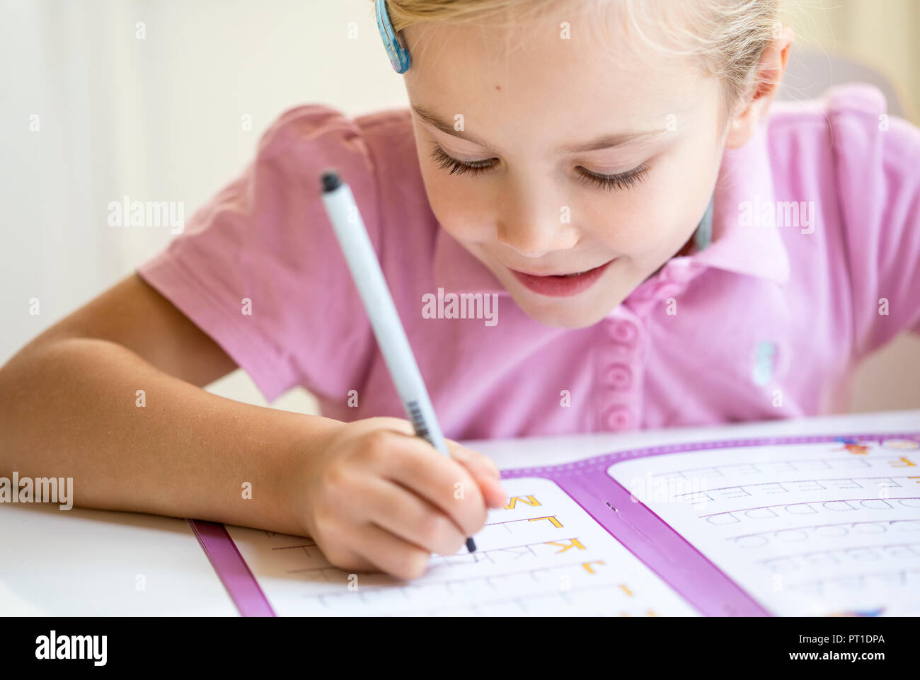 Smiling little girl alphabet écriture Banque D'Images