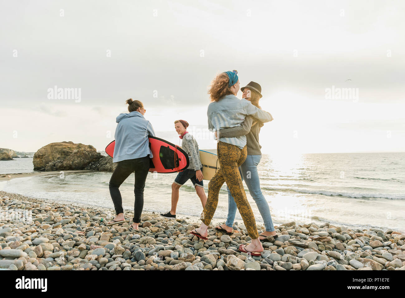 Happy friends avec planches de marche sur Stony Beach Banque D'Images