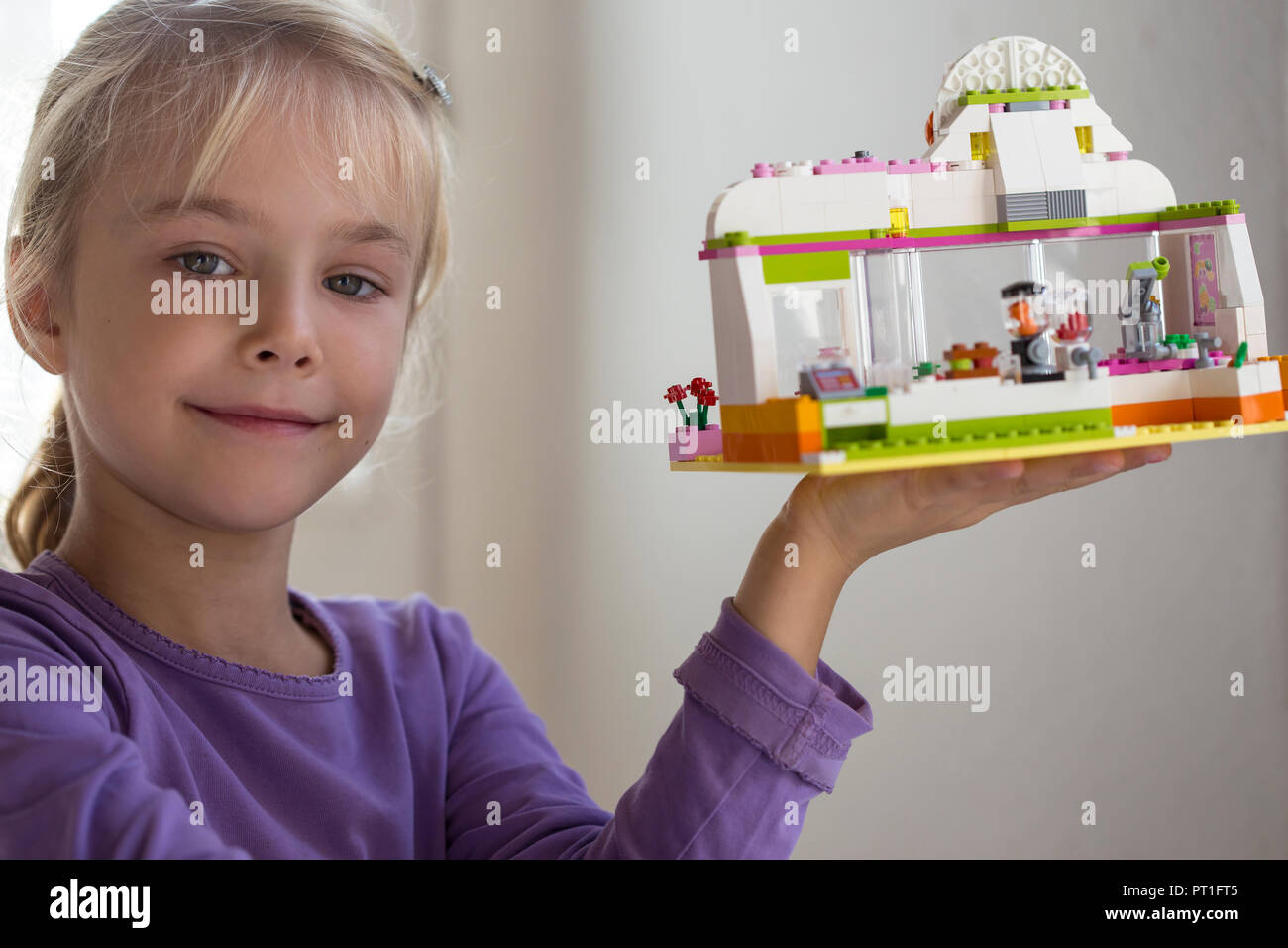 Portrait of smiling little girl présentation toy house Banque D'Images