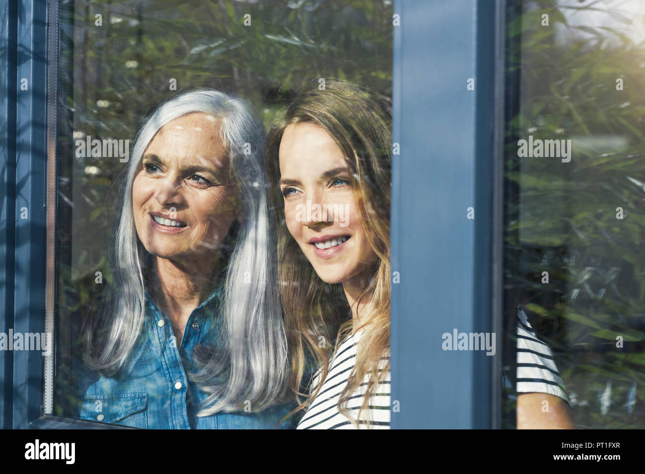 Mère et fille à la fenêtre de Banque D'Images