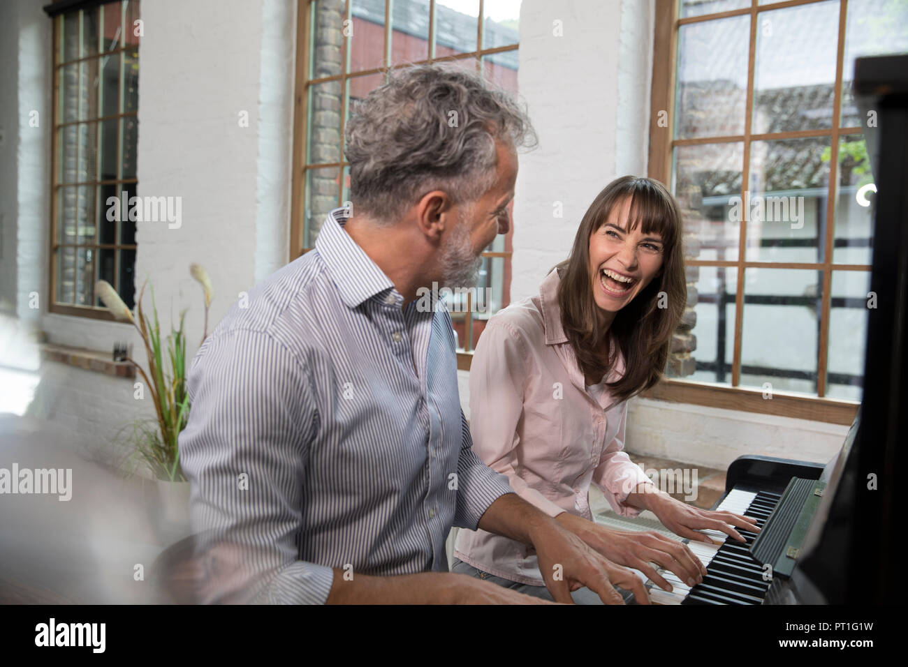 D'âge mûr s'amusant à la maison, à jouer du piano Banque D'Images