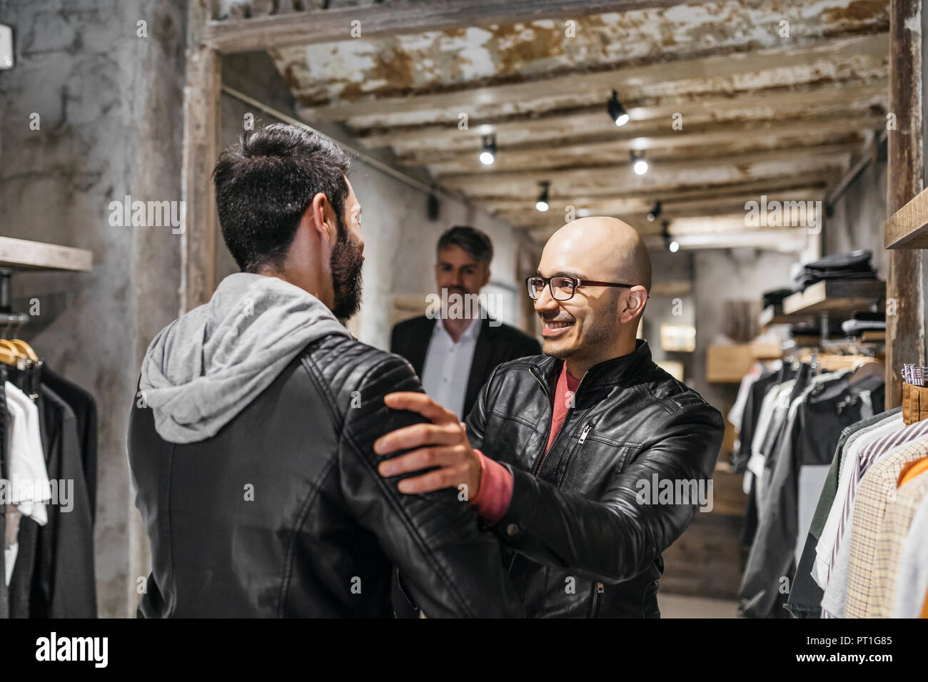 Deux hommes souriant en réunion boutique de vêtements pour homme moderne Banque D'Images