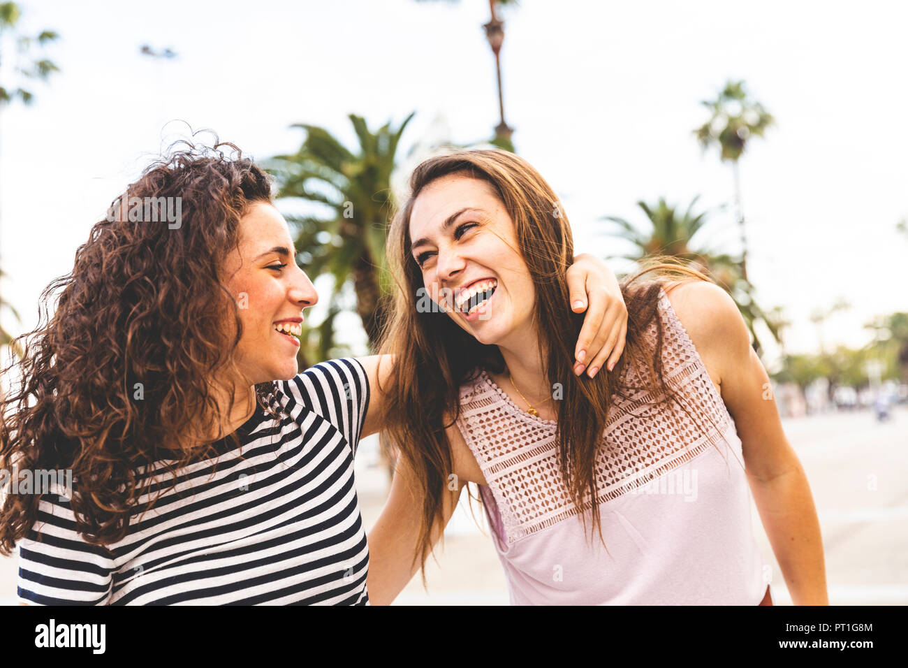 Deux heureux amis féminins sur la promenade de palmiers Banque D'Images