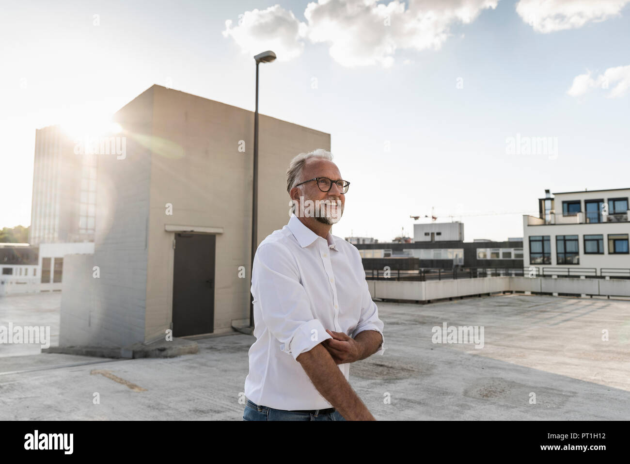 Couple sur le toit d'un immeuble de grande hauteur, retrousser les manches Banque D'Images