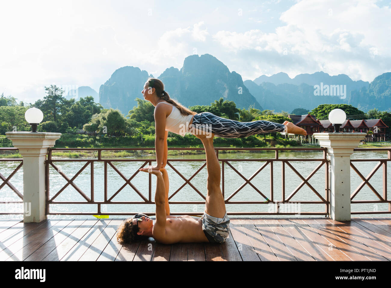 Le Laos, Vang Vieng, jeune couple faisant l'acro-yoga sur une terrasse Banque D'Images