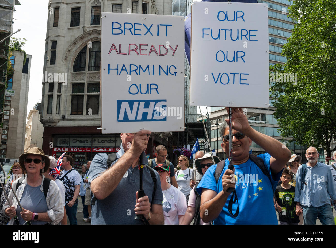 Deux hommes souriant sur Anti-Brexit manifestation en soutien du deuxième référendum, portant des pancartes 'Brexit déjà nuit à notre NHS' et 'Notre avenir notre vote" Banque D'Images