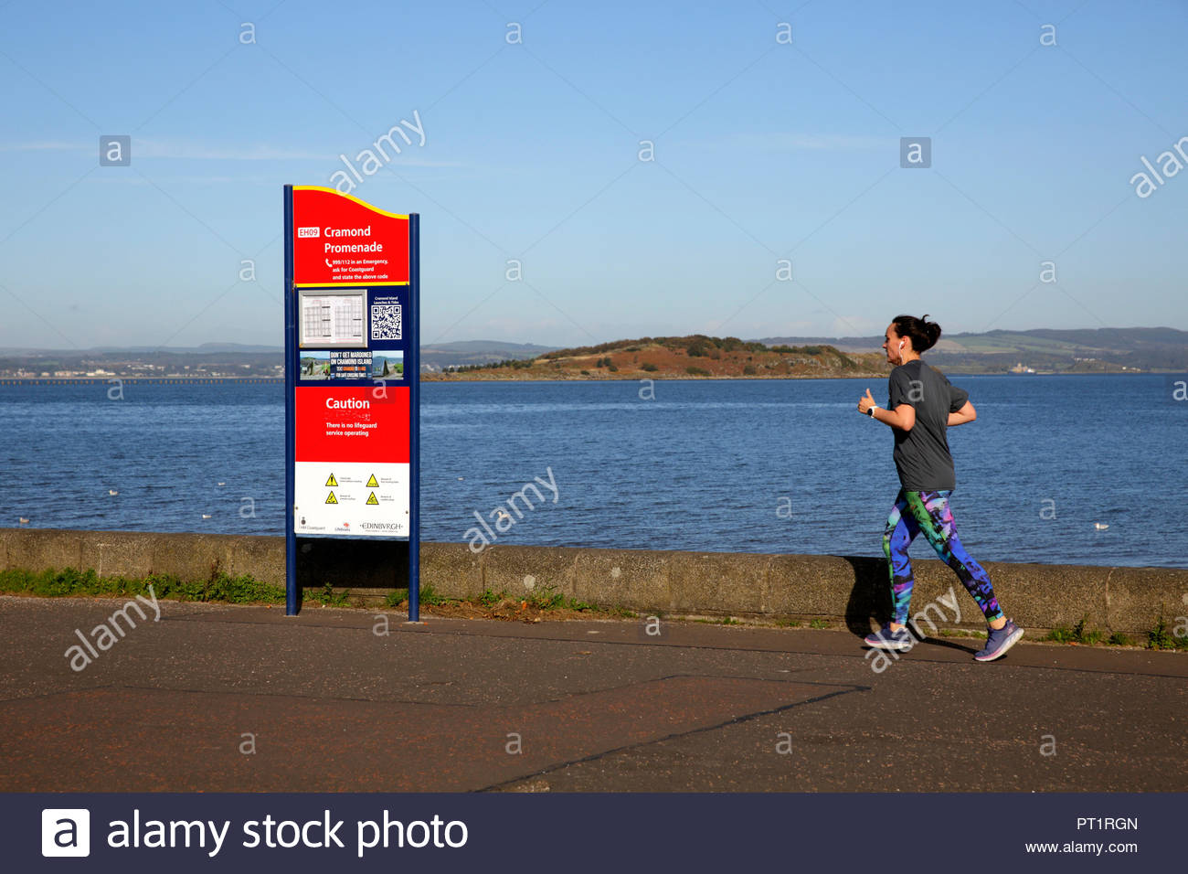 Edinburgh, Royaume-Uni, le 5 octobre 2018. Jogger bénéficiant du beau temps avec un ciel bleu à Cramond, Promenade. L'île de Cramond visible. Credit : Craig Brown/Alamy Live News. Banque D'Images
