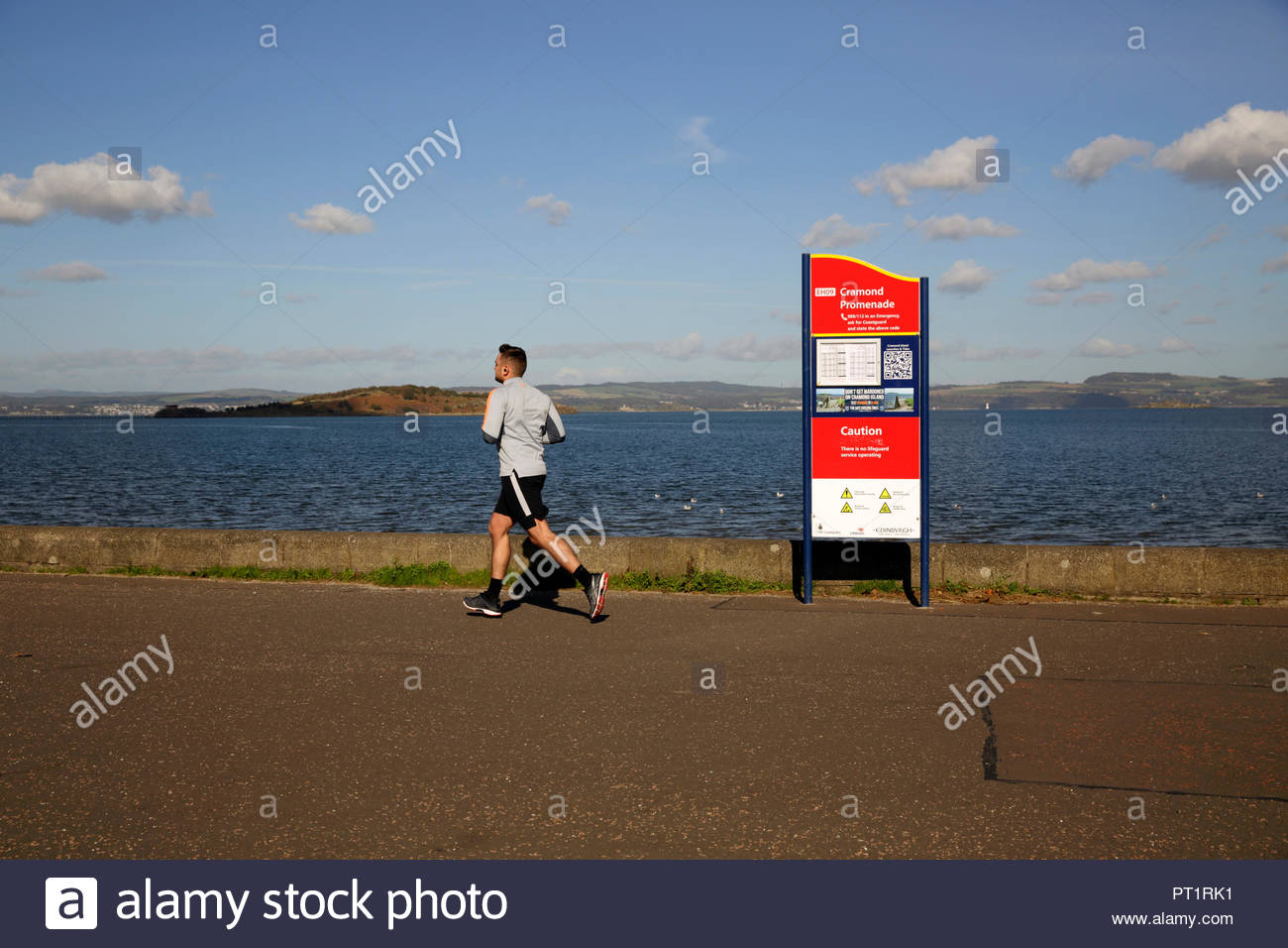Edinburgh, Royaume-Uni, le 5 octobre 2018. Jogger bénéficiant du beau temps avec un ciel bleu à Cramond, Promenade. Credit : Craig Brown/Alamy Live News. Banque D'Images