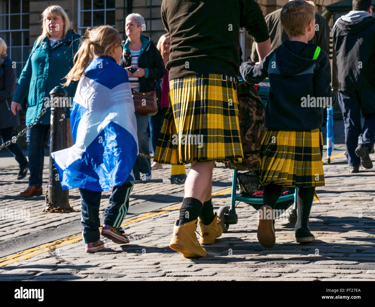 Holyrood, Édimbourg, Écosse, Royaume-Uni, 6 octobre 2018. Tous sous une même bannière (AUOB écossais) et Mars Rassemblement pour l'indépendance, avec des partisans marche sur la Royal Mile, à Holyrood Park pour un rassemblement. AOUB est un pro-indépendance pour la campagne, dont le cœur de but est de mars à intervalles réguliers jusqu'à l'Écosse obtient l'indépendance. Un père et son fils, marcher jusqu'à la Royal Mile à rejoindre la marche à porter le kilt en tartan et une fille rideaux un sautoir drapeau écossais sur ses épaules Banque D'Images